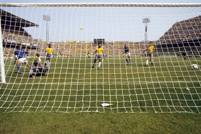 Italy's Paolo Rossi (l) slides the ball past Brazil goalkeeper Waldir Peres (second l) to score the winning goal as Brazil's Junior (third l), Luisinho (third r) and Oscar (r), and Italy's Francesco Graziani (second r), look on