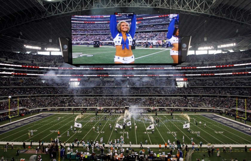 A member of the Dallas Cowboys cheerleaders is seen on the video screen at Cowboys Stadium during introductions before an NFL football game against the Miami Dolphins Thursday, Nov. 24, 2011, in Arlington, Texas. (AP Photo/Matt Strasen )